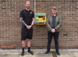 Benny and Louis stood next to defibrillators image via @Sclmembers instagram