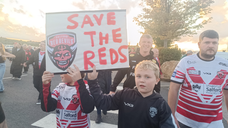 "Save The Reds" - Young Salford Red devils fan holds sign at the 1873 protest